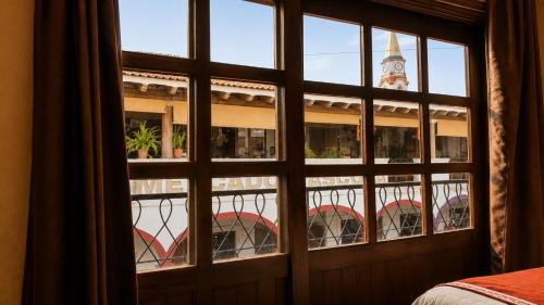 Blick aus einem Fenster auf ein Gebäude mit einem Uhrturm in der Unterkunft Copa de Oro Hotel Boutique in Mascota