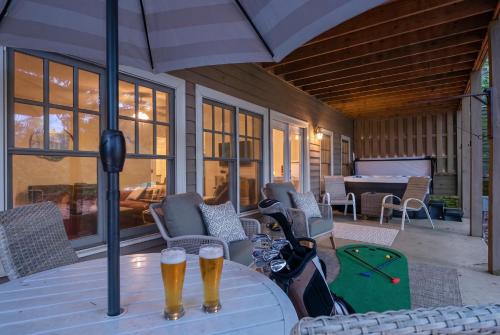 two beer bottles on a table on a patio at K-Tees Cottage - Big Canoe,GA - Soak in the Private Hot Tub, Challenge Friends in the Arcade, Take in Scenic Golf Course Views, in Holcomb