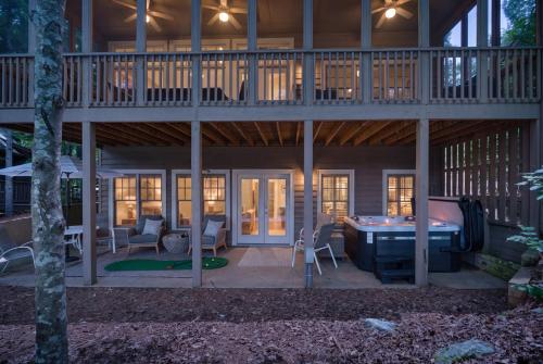 a large house with a pool table in the backyard at K-Tees Cottage - Big Canoe,GA - Soak in the Private Hot Tub, Challenge Friends in the Arcade, Take in Scenic Golf Course Views, in Holcomb