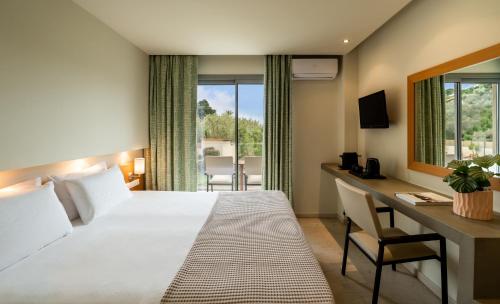 a hotel room with a large bed and a desk and a window at Astoria Hotel in Troulos