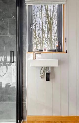 a bathroom with a sink and a window at Oakwood Marina in Northwich