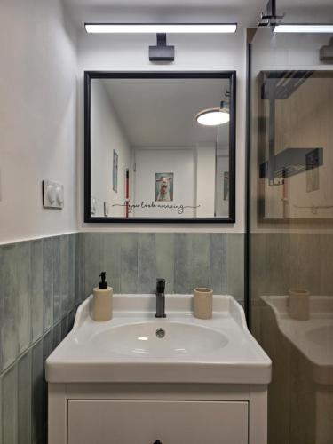 a bathroom with a white sink and a mirror at Kalamea Apartment Kalathas in Kalathas