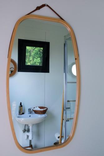 a bathroom with a mirror and a sink at bosco glamping in Modrzewek