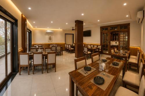 a dining room with wooden tables and chairs at Hotel Kartikey Near Jio Centre in Sundarnagar