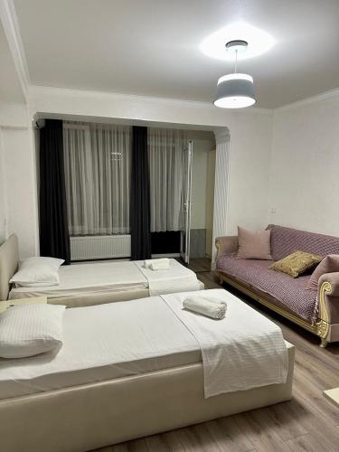 a hotel room with two beds and a couch at HOTEL Old Boulevard BATUMI in Batumi