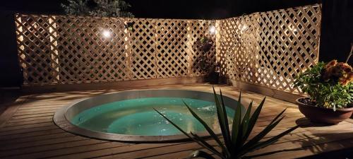 a hot tub on a wooden deck with potted plants at Lily Home in Algarrobo
