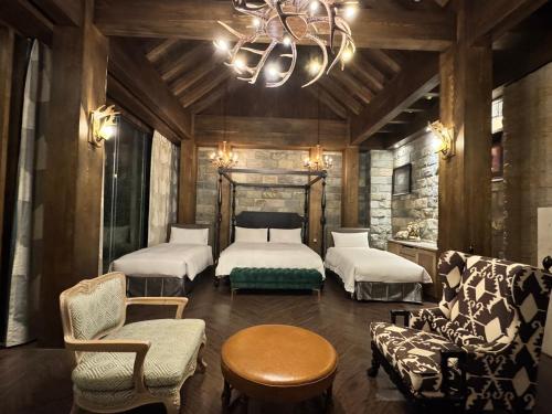 a bedroom with two beds and a couch and a chandelier at The Castle Ballet Taichung A Boutique Hotel in Taichung