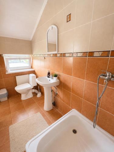 a bathroom with a tub and a toilet and a sink at Готель Українське in Vinnytsya