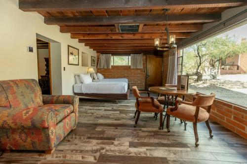 a living room with a bed and a table and chairs at Tanque Verde Guest Ranch in Tucson