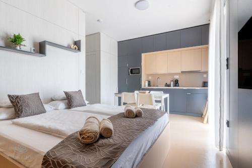 a bedroom with a bed with slippers on it at Aqua Rosa Tiszafüred 2 in Tiszafüred
