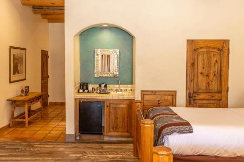 a bedroom with a bed and a sink and a mirror at Tanque Verde Guest Ranch in Tucson
