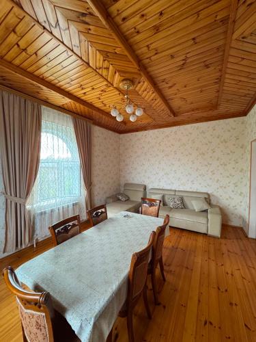 a dining room with a table and chairs and a couch at Palm Garden House Lankaran in Lankaran