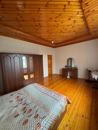 a bedroom with a bed and a wooden ceiling at Palm Garden House Lankaran in Lankaran