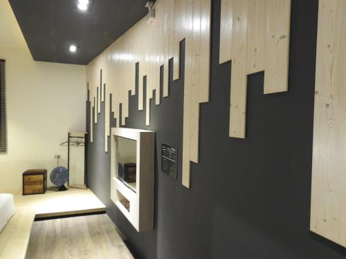 a room with a wall that has some art on it at True-FDs Inn in Xiaoliuqiu