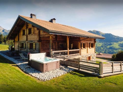 a large wooden house with a hot tub in front of it at Pralor Le Peille - OVO Network in Manigod