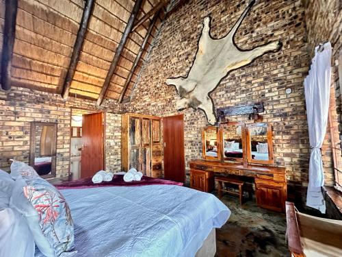 a bedroom with a bed and a dresser with a deer head on it at Zaganaga Kruger Lodge in Marloth Park