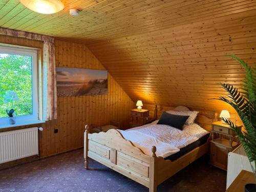 a bedroom with a bed in a wooden room at Fehntjer Ferienhof nahe Idasee in Ostrhauderfehn
