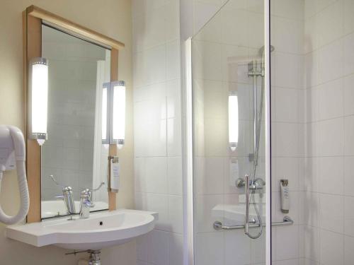 a white bathroom with a sink and a shower at ibis Poitiers Centre in Poitiers