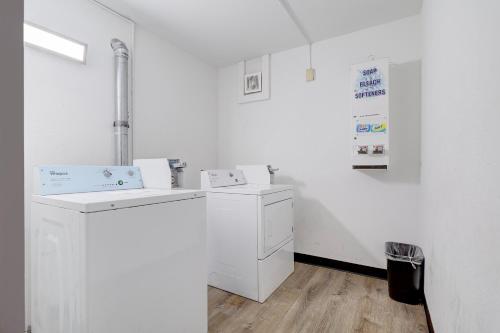 a white laundry room with a washer and dryer at Coldwater Inn & Suites near I 69 in Coldwater