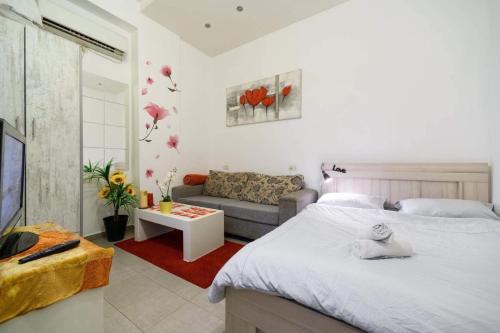 a living room with a bed and a couch at דירת סטודיו ליד הים ברחוב בוגרשוב המבוקש in Tel Aviv
