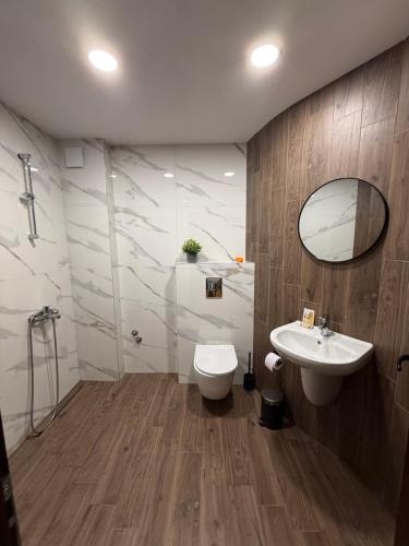 a bathroom with a sink and a toilet and a mirror at Motel Eros in Sandanski