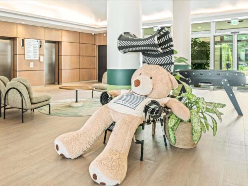 a teddy bear sitting on a chair in a lobby at Novotel Paris Charenton le Pont in Charenton-le-Pont