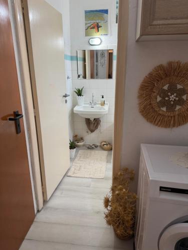 a bathroom with a sink and a washing machine at Traditional Villa Stella in Archangelos