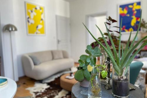 a living room with a table with vases and plants at Bright apartment - old renovated building in Nantes