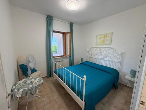 a bedroom with a blue bed and a window at Villa Marina piano terra in Rio Marina