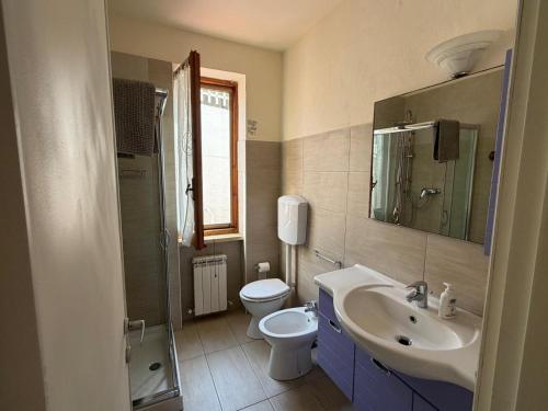 a bathroom with a sink and a toilet and a mirror at Villa Marina piano terra in Rio Marina