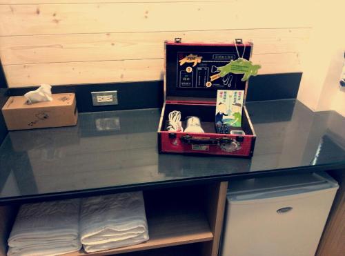 a shelf with a table with a suitcase on it at True-FDs Inn in Xiaoliuqiu
