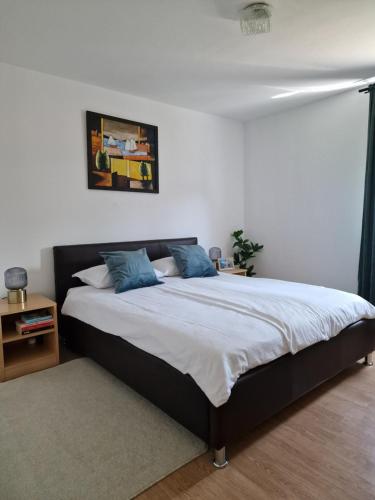 a bedroom with a large bed with blue pillows at Miljana in Vukovar
