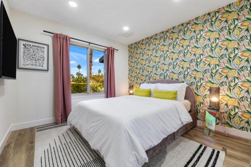 a bedroom with a large bed with a colorful wall at Acacia Retreat by Rather Be Properties in Palm Springs