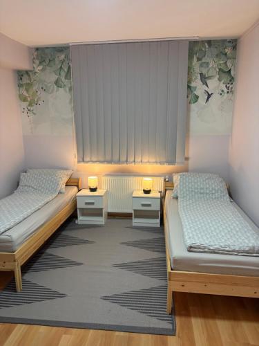 a room with two beds and two night stands at Otthonos lakás in Kerepes