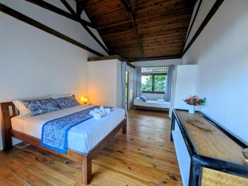 a bedroom with a bed and a wooden floor at Fare Tihi Moana in Tahu-Naoe