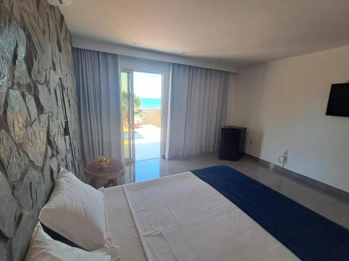 a bedroom with a large bed and a stone wall at Vilamar in Tibau do Sul
