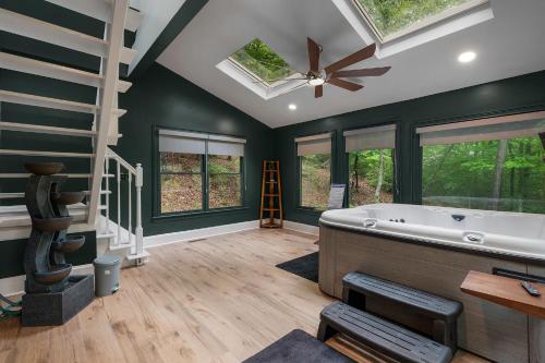 a large bathroom with a tub and a ceiling fan at Modern Marble - Jasper, GA - Take in Sweeping Mountain Views, Soak in the Hot Tub, Stay Active in the Home Gym, and Mix Drinks a in Jasper
