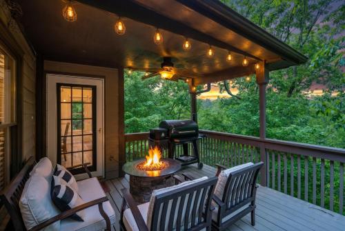 a screened in porch with a fire pit and chairs at Modern Marble - Jasper, GA - Take in Sweeping Mountain Views, Soak in the Hot Tub, Stay Active in the Home Gym, and Mix Drinks a in Jasper