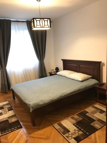 a bedroom with a bed and a window at Apartment KronDays in Braşov