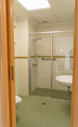 a bathroom with a shower and a toilet and a sink at Hotel GR in Tobarra