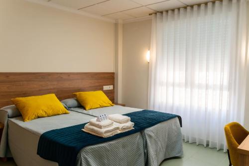 a bedroom with a bed with towels on it at Hotel GR in Tobarra