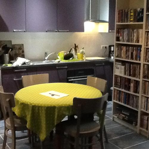 une cuisine avec une table et un chiffon de table jaune dans l'établissement Studio en pleine nature, à Choranche