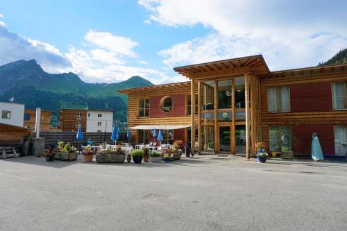 a building with flowers in front of it with mountains at Shima-Davos in Davos