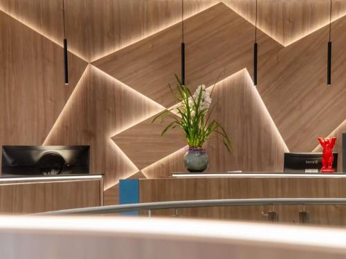 a room with a vase with a plant in it at Mercure Hotel Berlin Tempelhof in Berlin