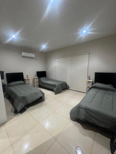 a room with two beds and a white floor at Las Moras in Ezeiza