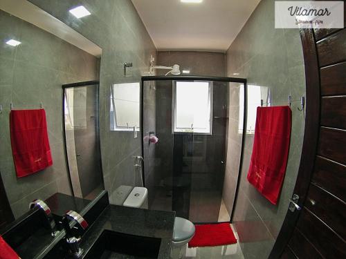 a bathroom with a sink and a shower with red towels at Vilamar in Tibau do Sul