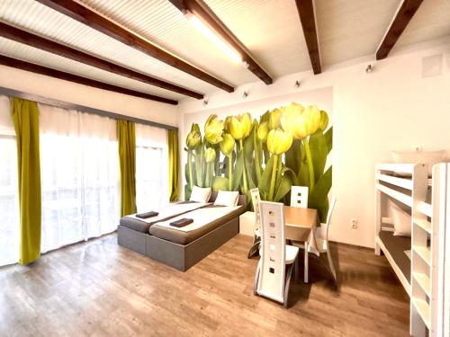 a room with a couch and a mural of yellow tulips at Tutti Apartman in Balatonlelle