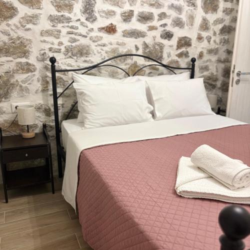 a bed with a pink blanket and white pillows at Villa Harmony in Kría Vrísi