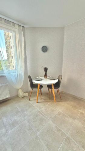 a dining room with a table and chairs and a window at НОВИЙ ЖК ОДЕСЬКІ ТРАДИЦІЇ НА ГЛУШКО!є підземний паркінг! in Odesa