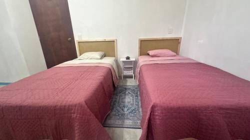 two beds sitting next to each other in a room at Casa ie in Santa María Azompa